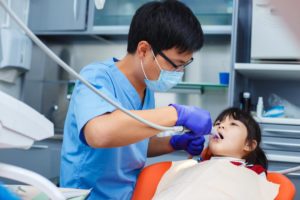 A dentist is performing a dental checkup on a child