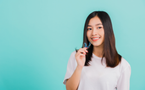 A girl is smiling brightly while wearing her clear dental aligner.