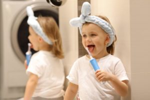 A child is holding an electronic toothbrush