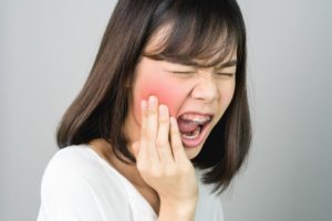 A lady with braces is experiencing a severe toothache