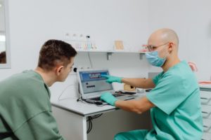 The dentist is showing the patient how the dental implant procedure should be done