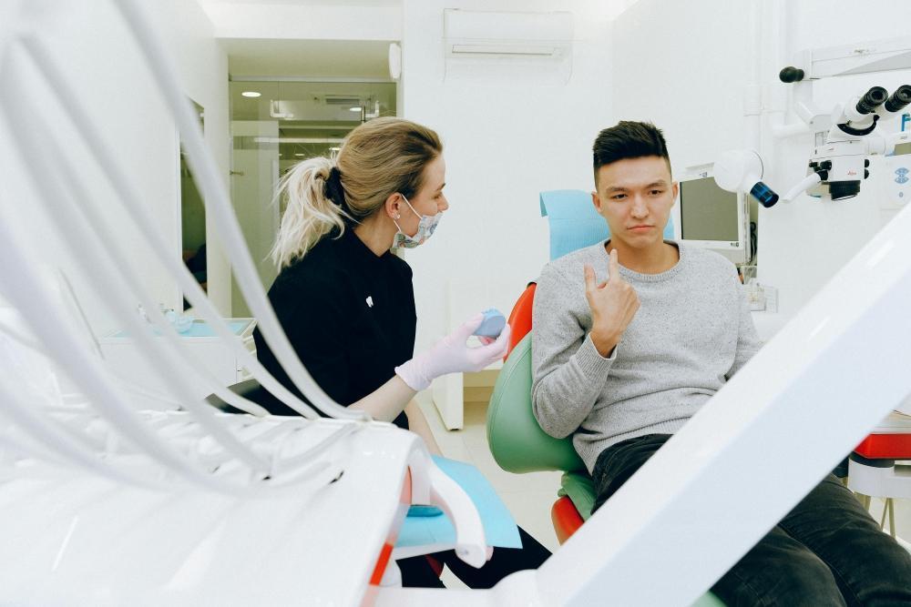 A dentist is helping the patient adjust their bite after a dental procedure.