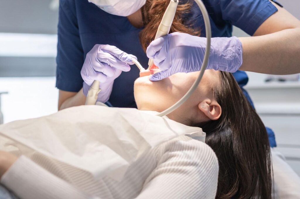 dentist perform a dental examination for a female patient