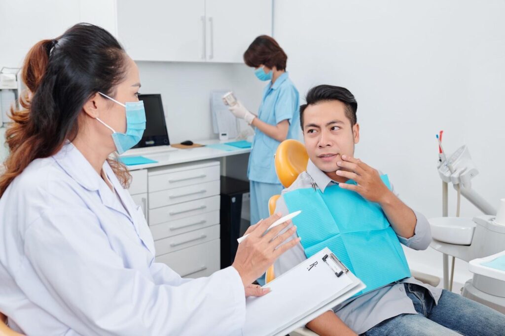 patient consulting dentist whether he should get root canal or extraction